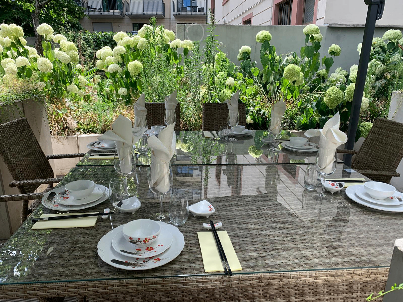 Gedeckter Tisch auf der Terrasse mit Hortensien und Kirschblüten-Porzellan